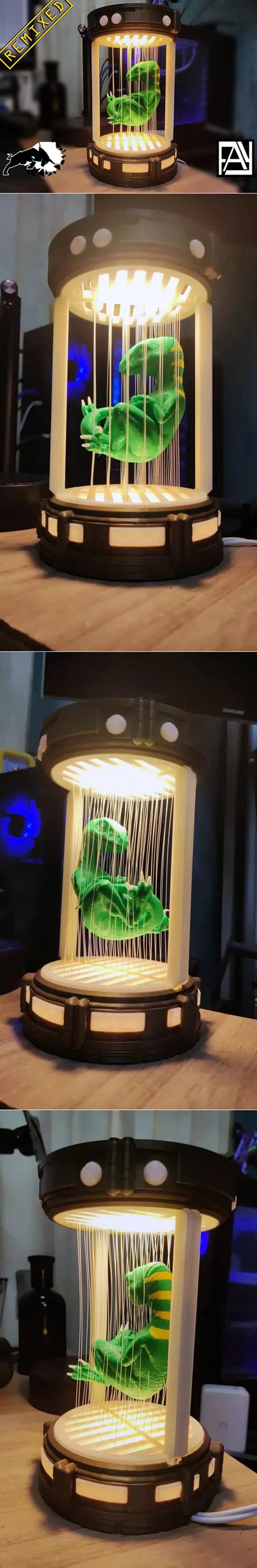 3D printed lamp with a green baby raptor suspended inside a futuristic incubator with LED lighting.