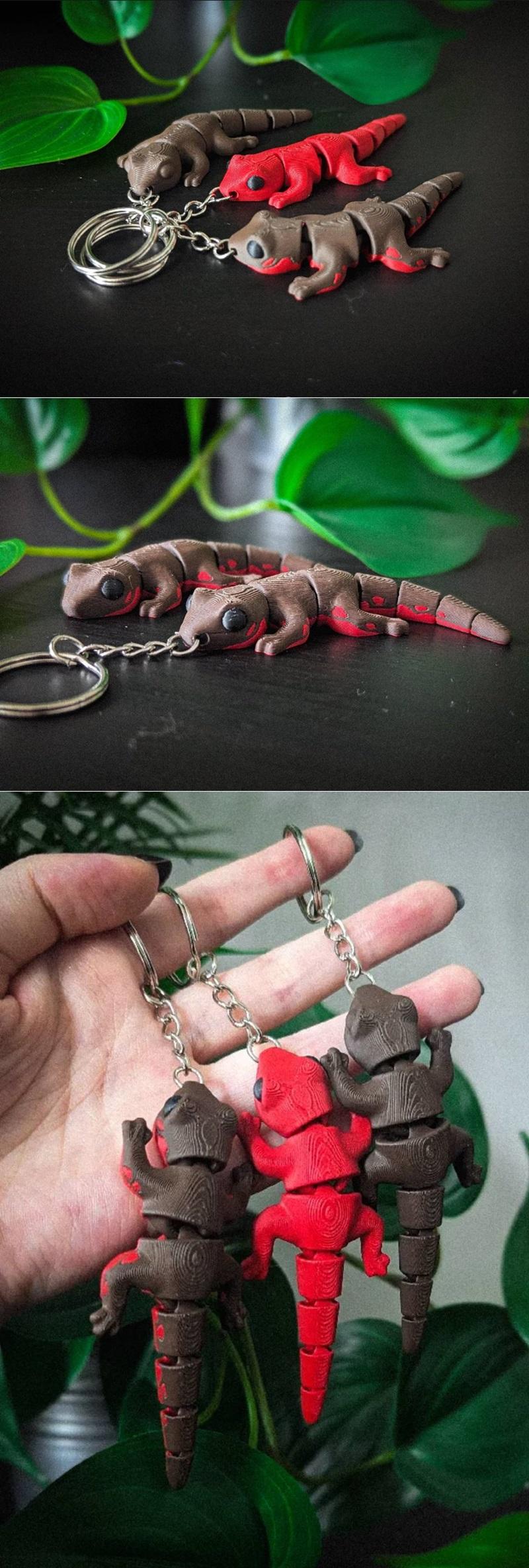 Three articulated Flexi Salamander keychains, two brown and one red, attached to keyrings. The models have segmented...