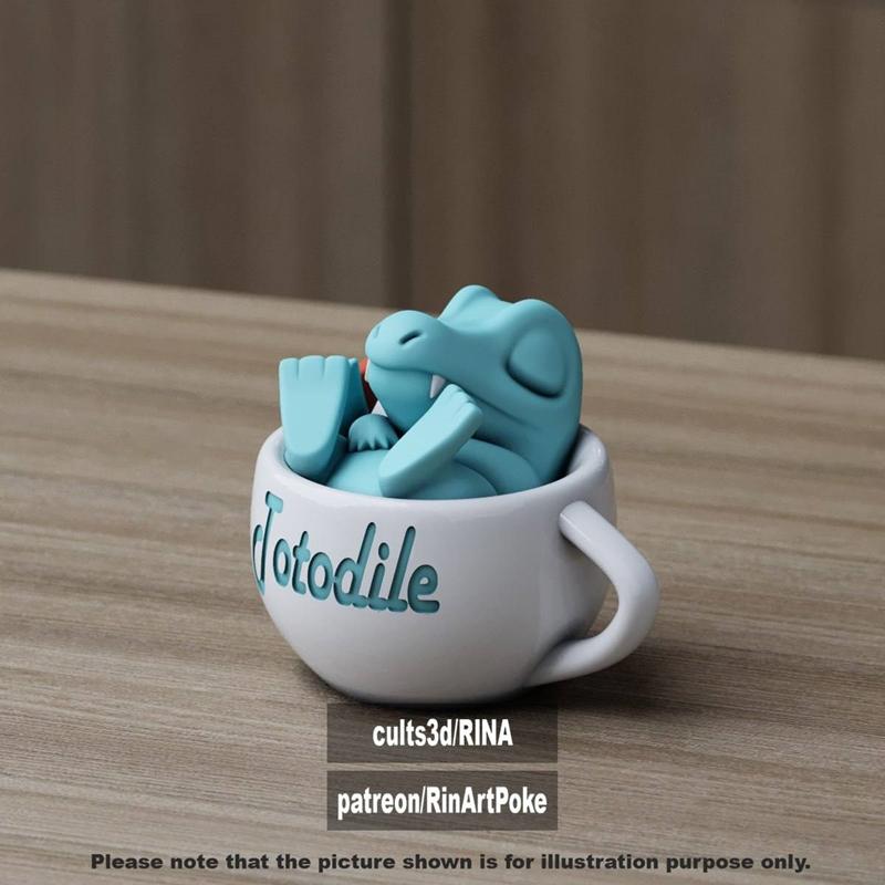 3D model of a blue Totodile character sleeping inside a white mug with its name printed on the side.