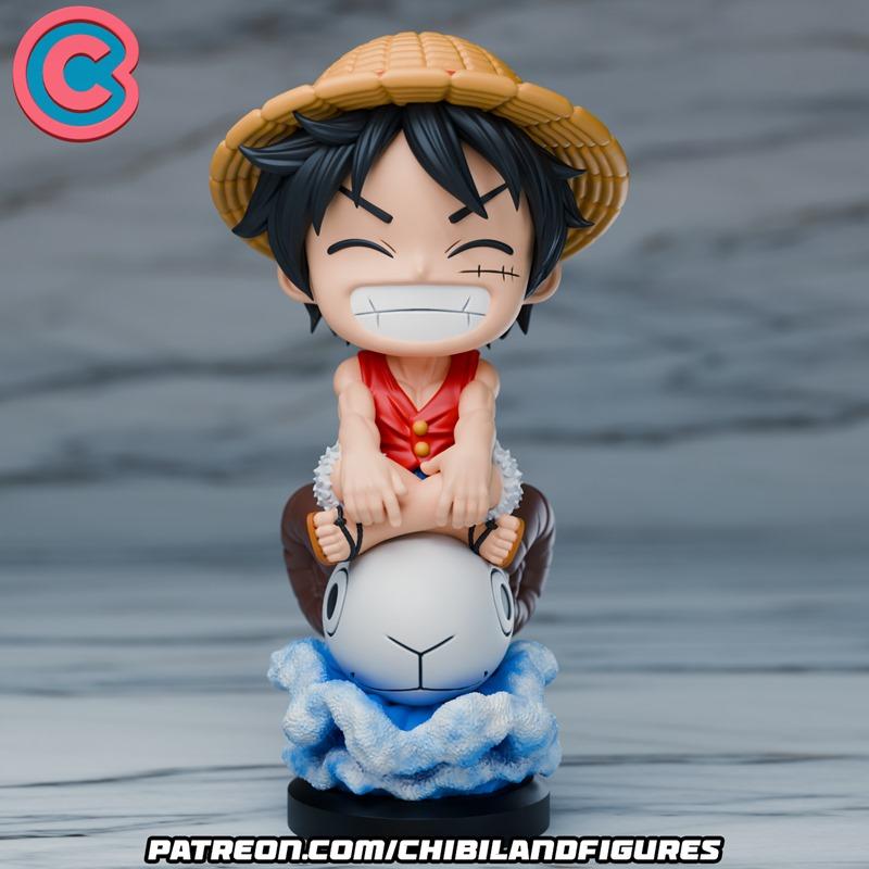 Chibi Luffy figure from One Piece, wearing a straw hat and red vest, sitting on a white creature with blue cloud-like...