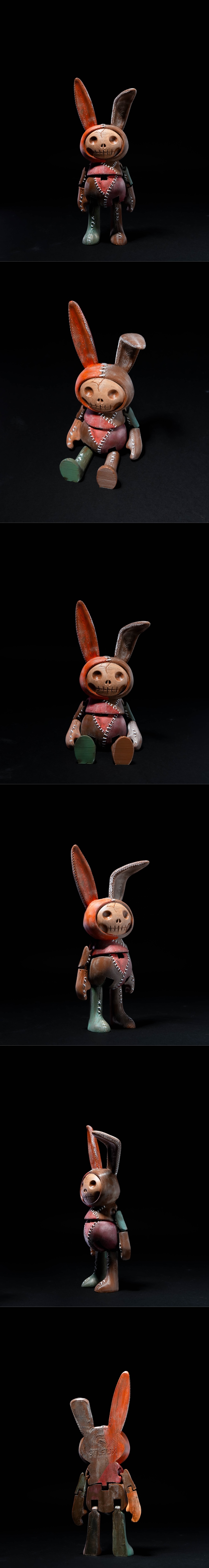 Articulated creepy bunny figure named Darko, with a skull face, stitched seams, and mismatched colored limbs, sitting...