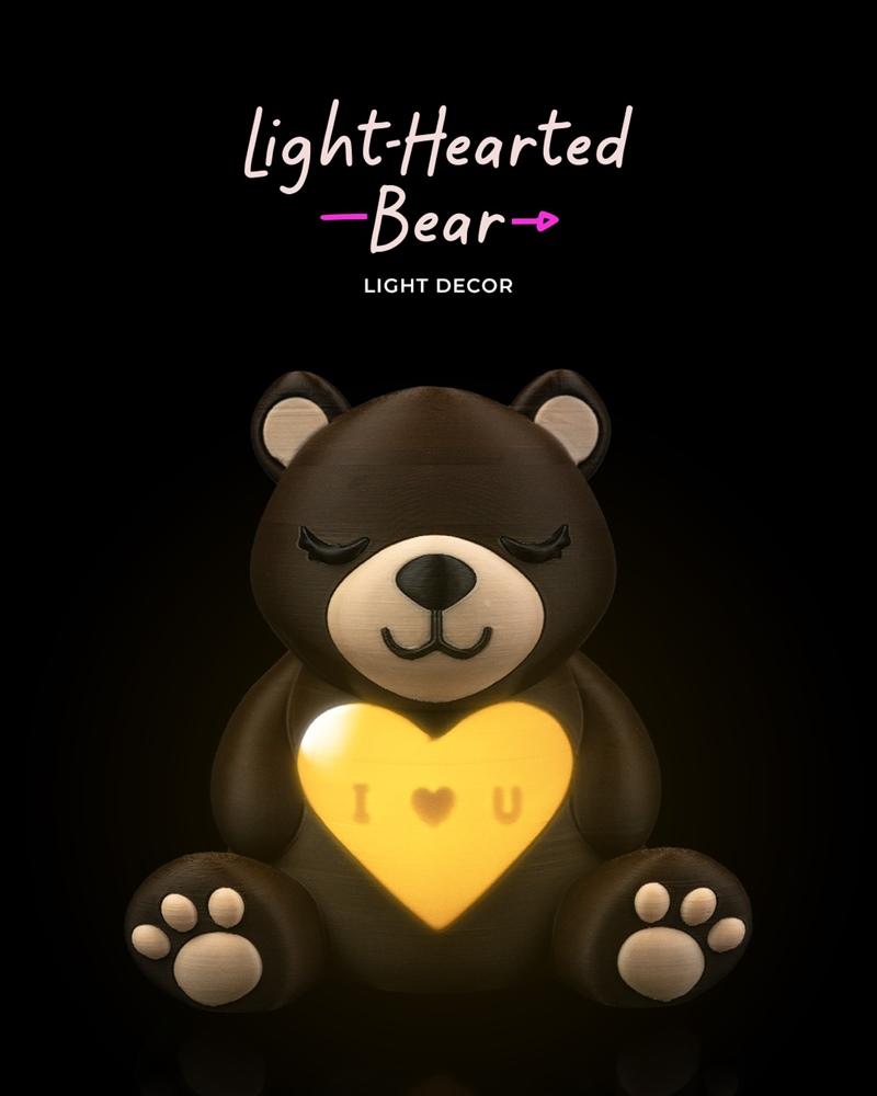 A 3D printed bear holding a glowing yellow heart with "I ♥ U" inscribed on it. The bear has closed eyes and...