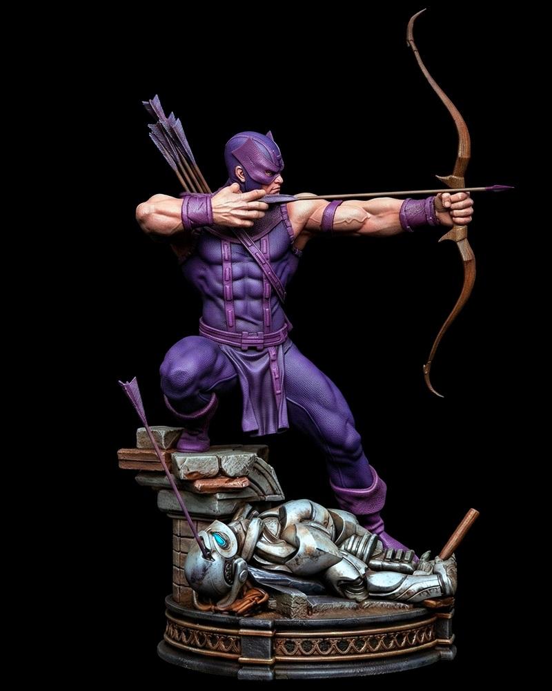 Hawkeye in purple costume drawing a bow and arrow, kneeling over a defeated robot on a stone base. Black Owl Customs...