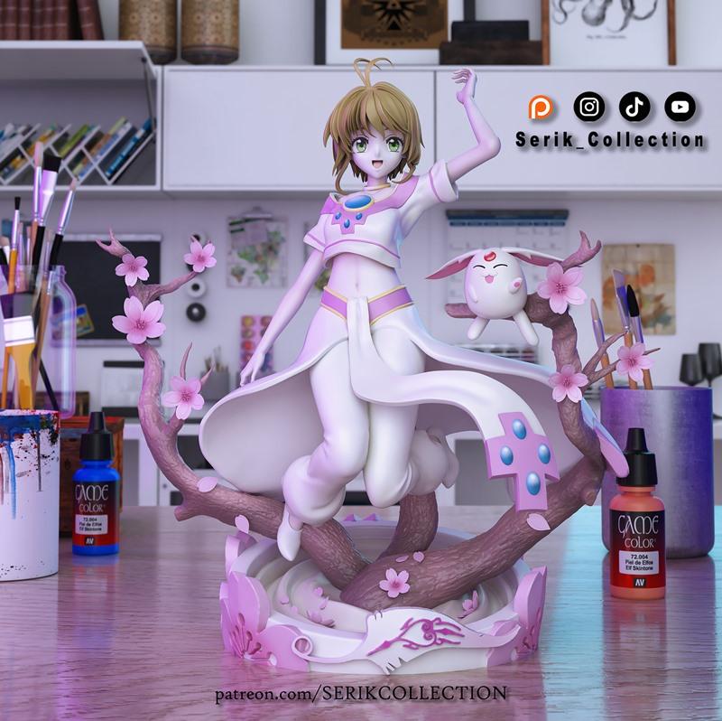 Sakura and Mokona from Tsubasa Reservoir Chronicle posed on a cherry blossom branch. Sakura wears a white and pink ou...
