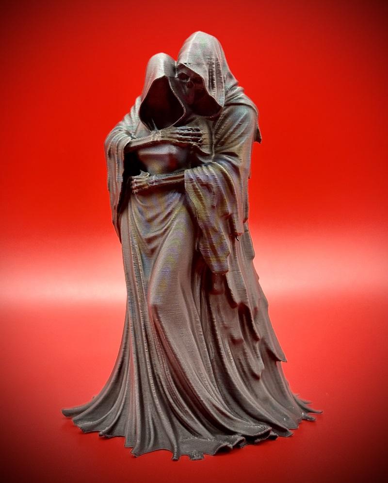 3D printed figure of Grim Reaper embracing Dark Empress, both in flowing hooded robes, against a red background.