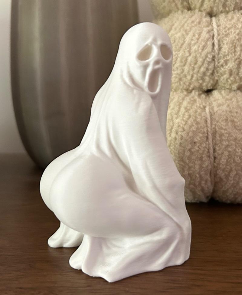 3D printed sculpture of a ghost in a provocative squatting pose, with a screaming face and exposed buttocks, draped i...