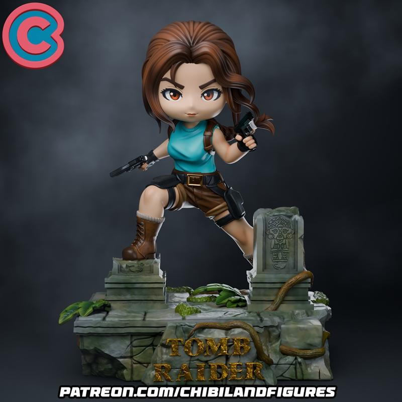 Chibi Lara Croft figure in action pose with two pistols, standing on a ruin base with "TOMB RAIDER" logo. S...