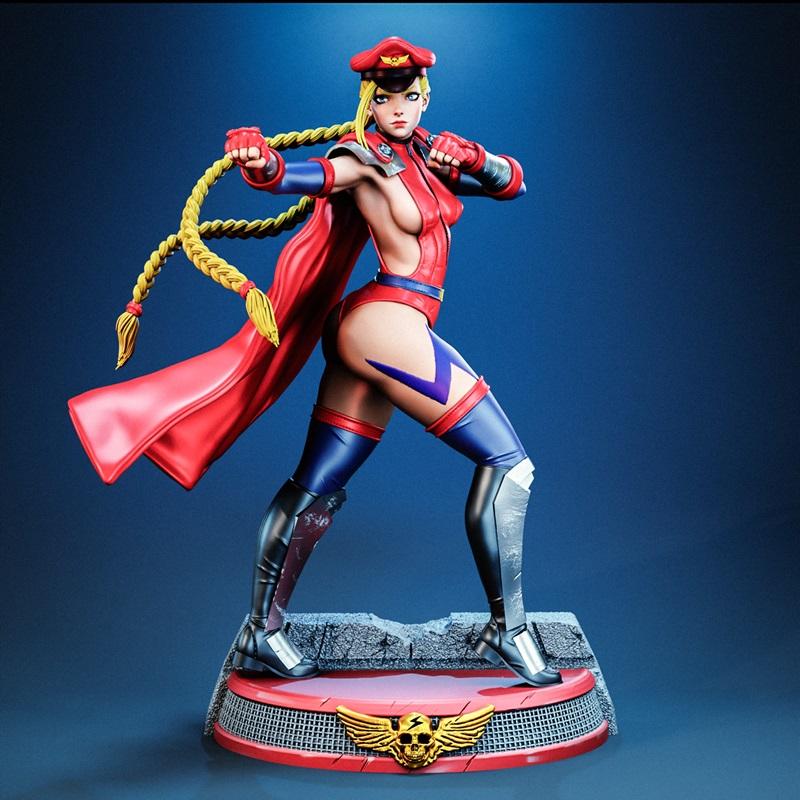 Cammy 3D model figure in combat stance, wearing red military uniform with blue accents, red cape, blonde braids, and...